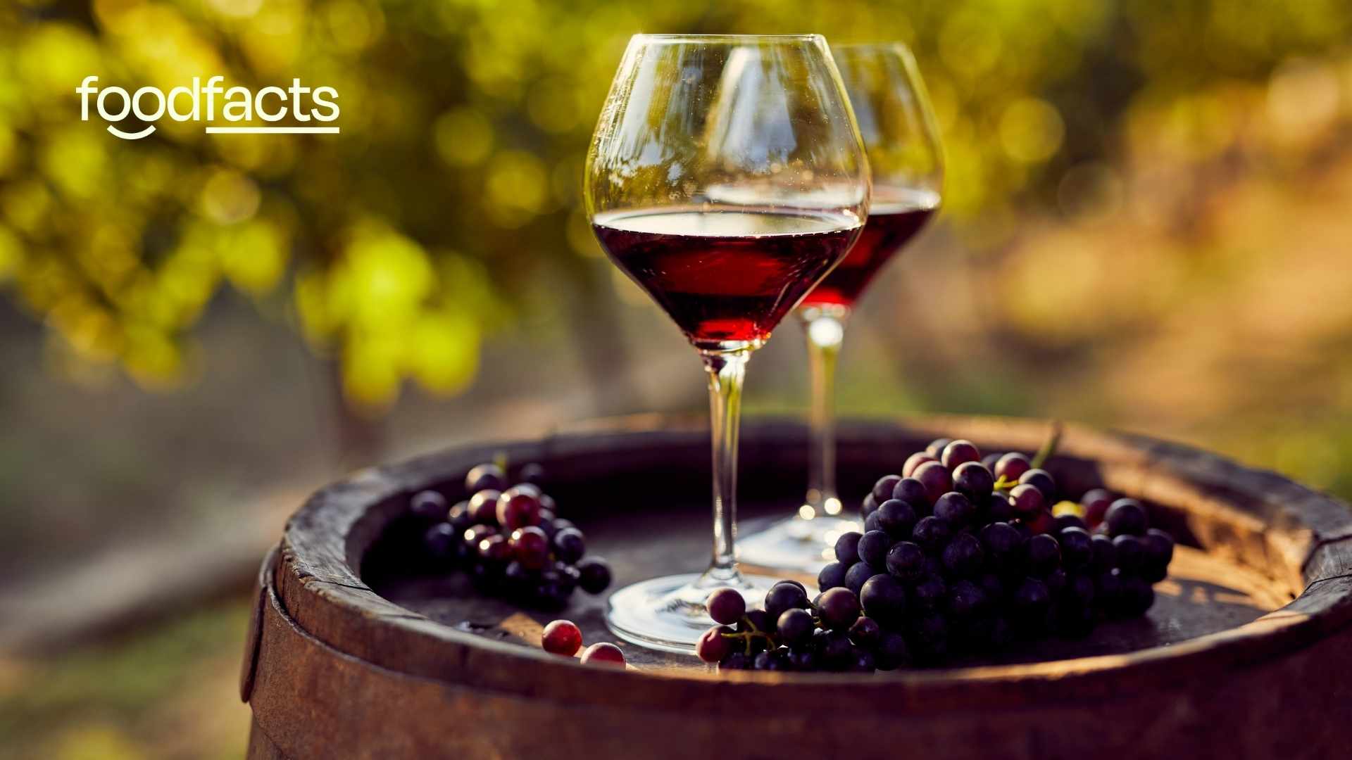 two glasses of red wine with grapes