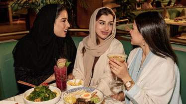 Friends dining at a restaurant inside Kingdom Centre Riyadh near Cloud Spaces enjoying gourmet meals and beverages