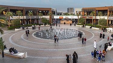 عائلات تستمتع بالساحة المفتوحة ومنطقة النوافير في مجمع واجهة روشن الرياض