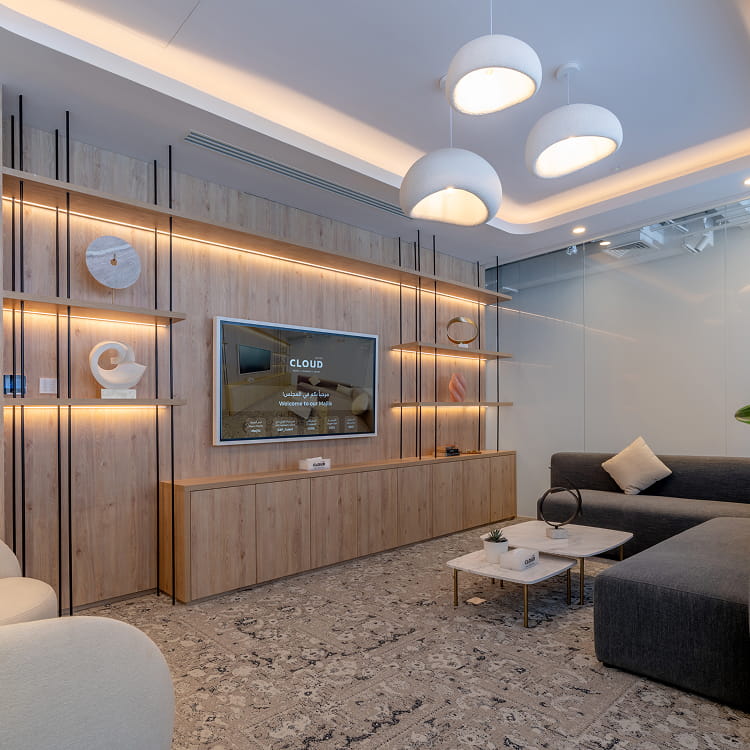 Relaxing Majlis-style lounge at Cloud Spaces Roshn Front with blue sofas and smart TV setup