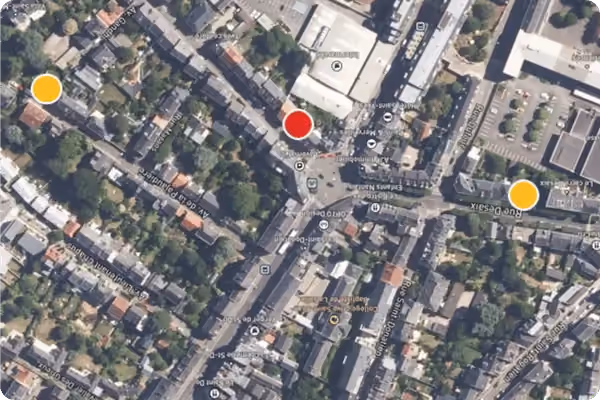 Vue aérienne d'un quartier urbain avec trois points de repère colorés marqués en rouge et orange sur la carte.