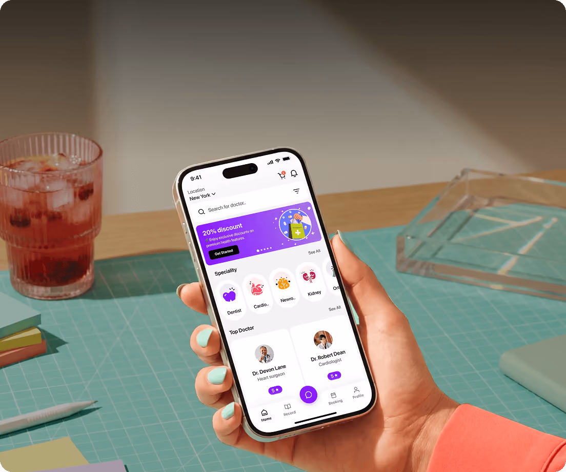 Hand holding smartphone showing a health app with doctor search, specialties, and top doctor ratings.