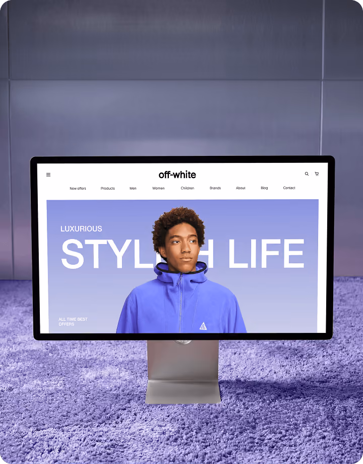 Computer screen on purple carpet shows fashion website with a man in a blue jacket and text Stylish Life.