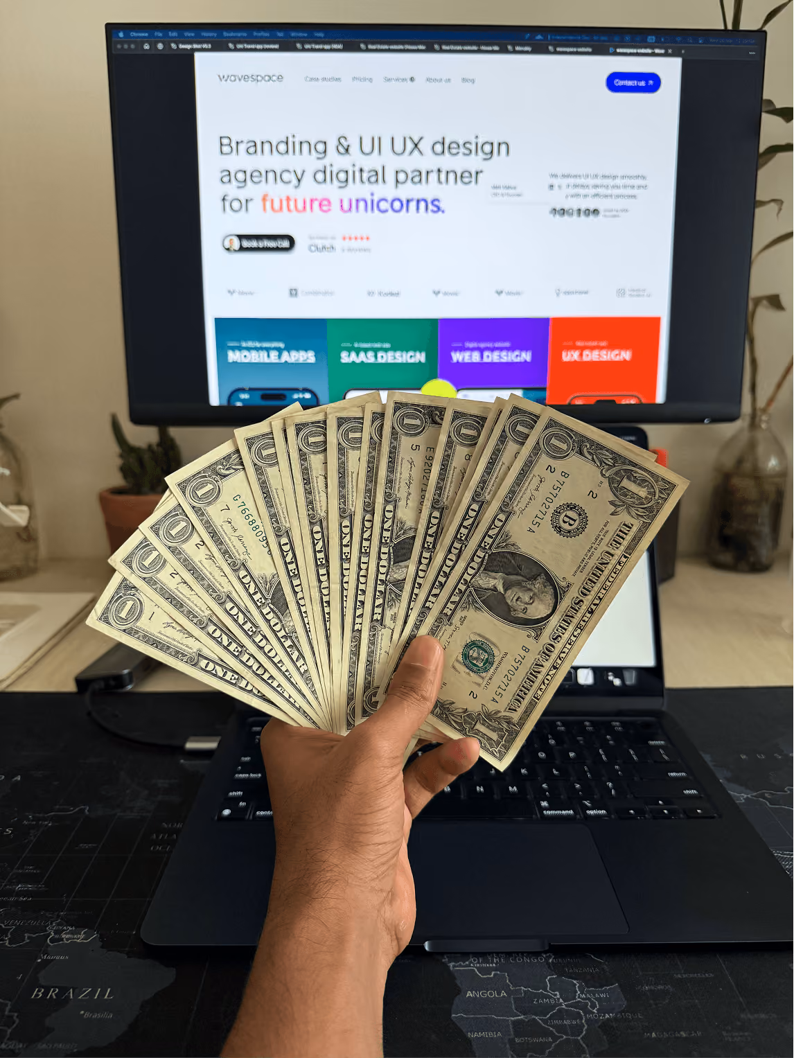 Holding cash in front of the Wavespace website