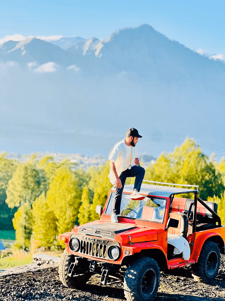 Standing on a jeep with a mountain view
