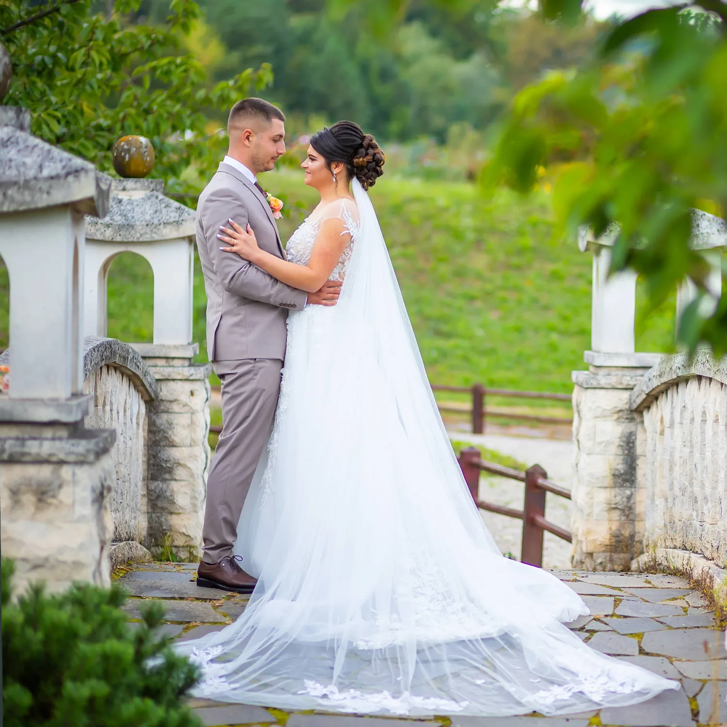 Miri îmbrățișați pe un pod de piatră, înconjurați de verdeață, surprinși de Flaviu Studio – fotografie de nuntă elegantă în aer liber.