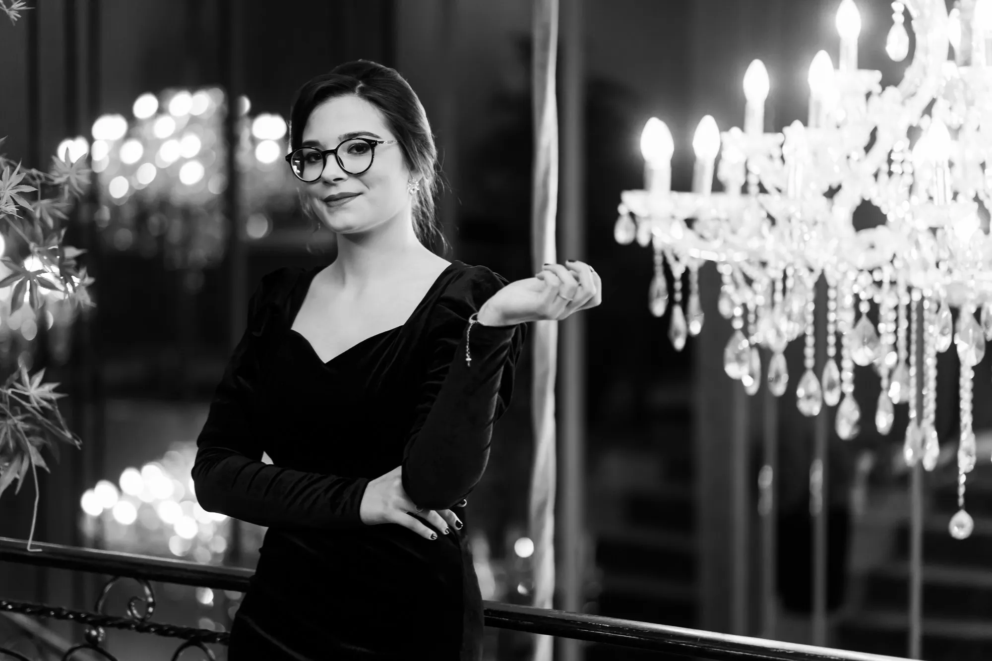 Fotografie de absolvire clasa a XII-a în stil alb-negru, realizată de Flaviu Studio – portret elegant al unei absolvente surprinse într-un decor rafinat, sub lumina candelabrelor.
