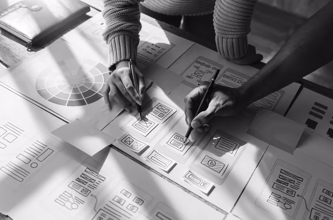 Two people stand over a table mapping out development plans using piecesof paper.
