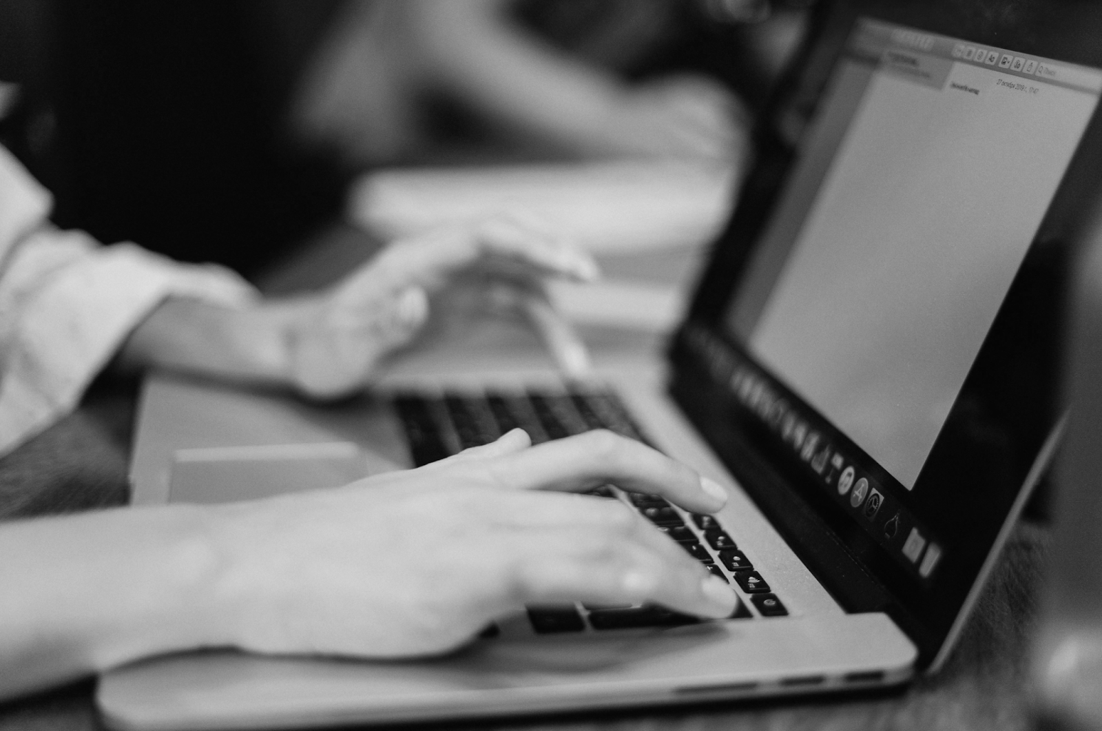 Hands type on a laptop.