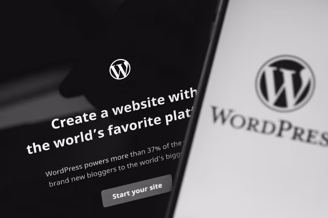 A mobile phone and a laptop display landing pages from Wordpress.com.