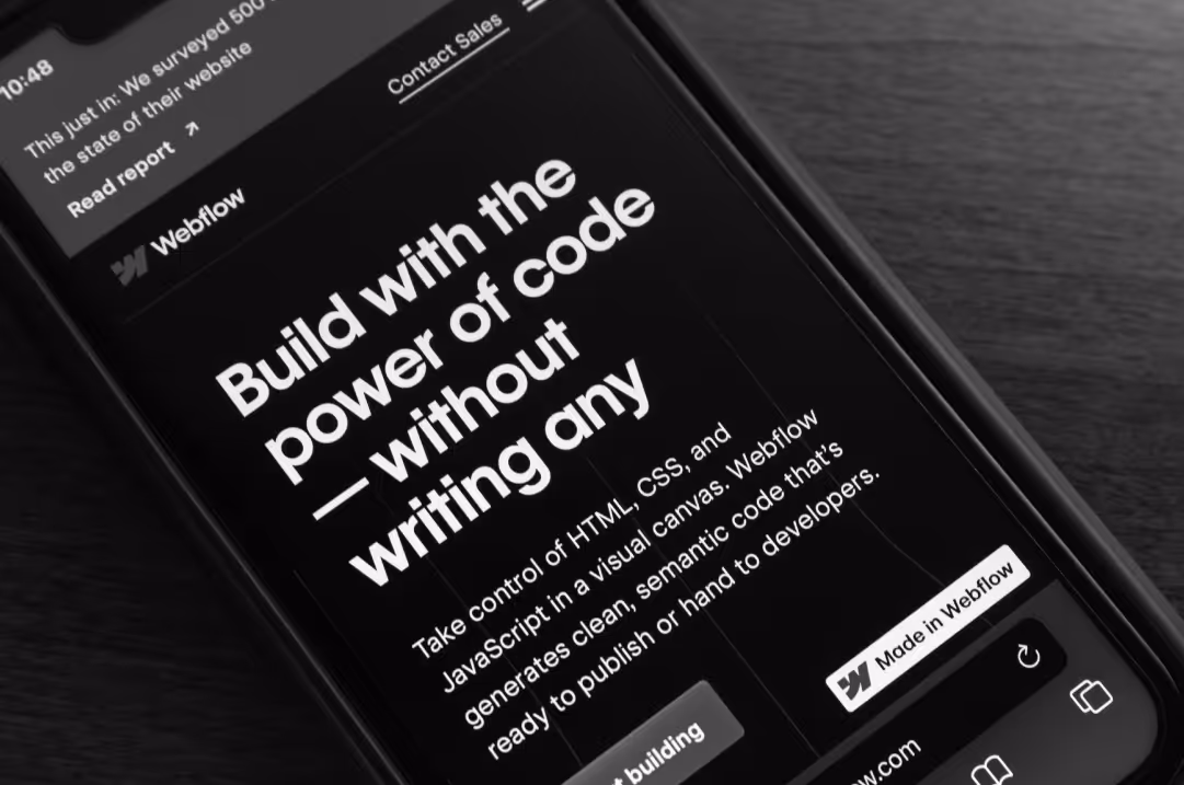 A mobile phone displays the Webflow homepage.