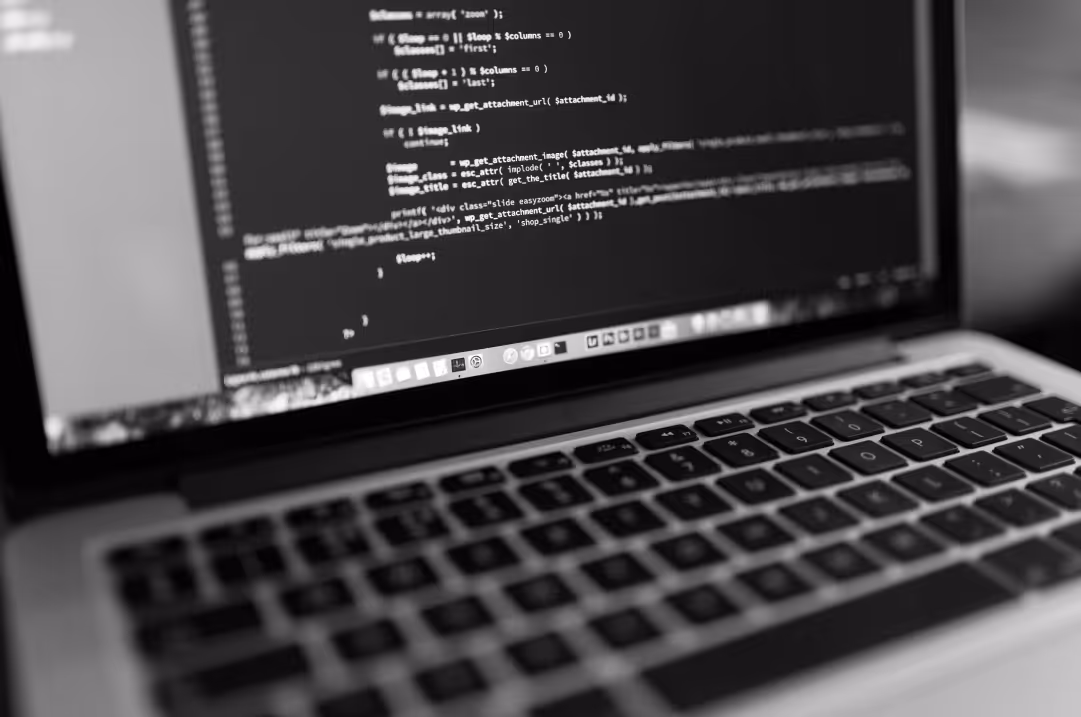 A laptop displays lines of code.