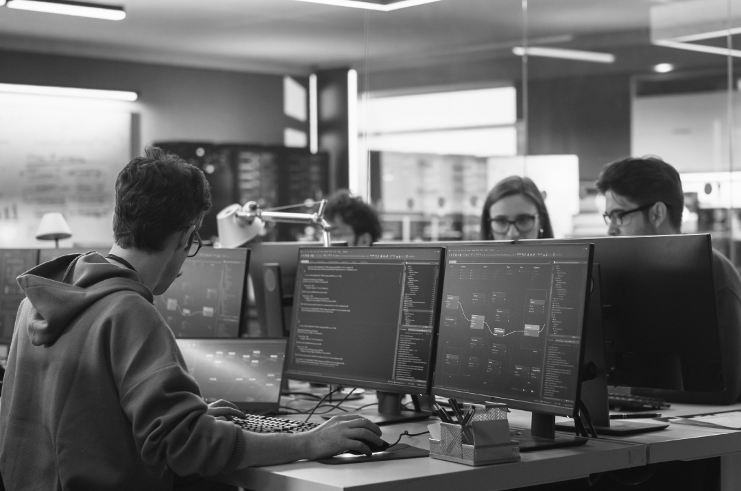 UX and software designer reviewing code and wireframes on screens.