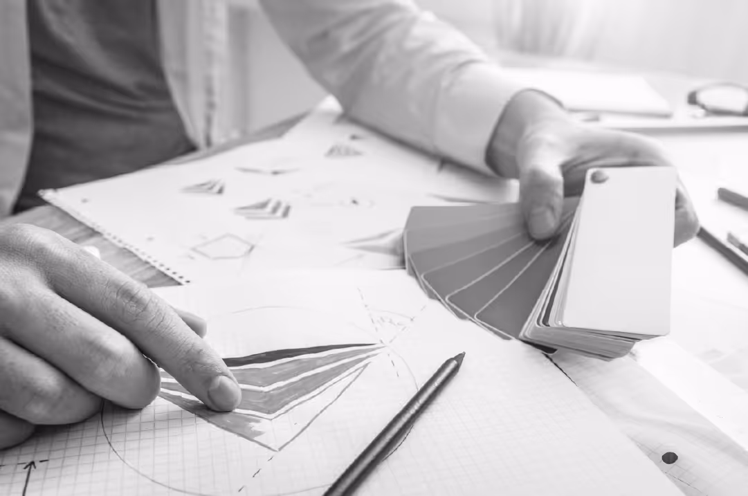 A person holds color swatches in their hand while reviewing documents.