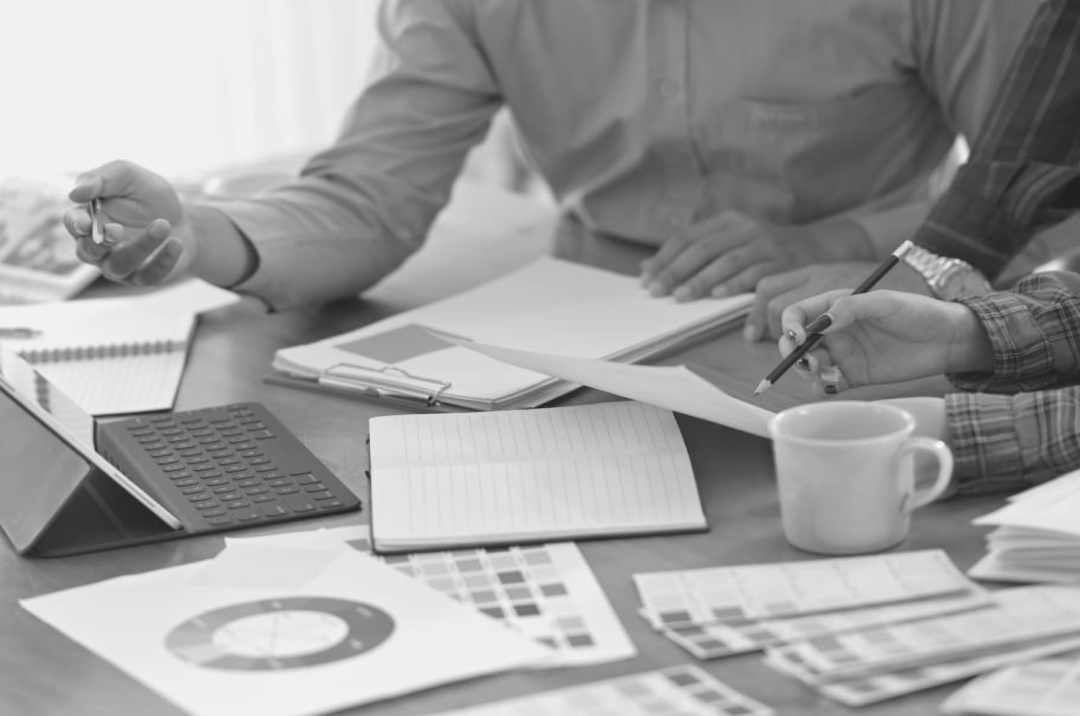 Design and strategy team reviewing digital branding trends with color palettes and analytics documents.