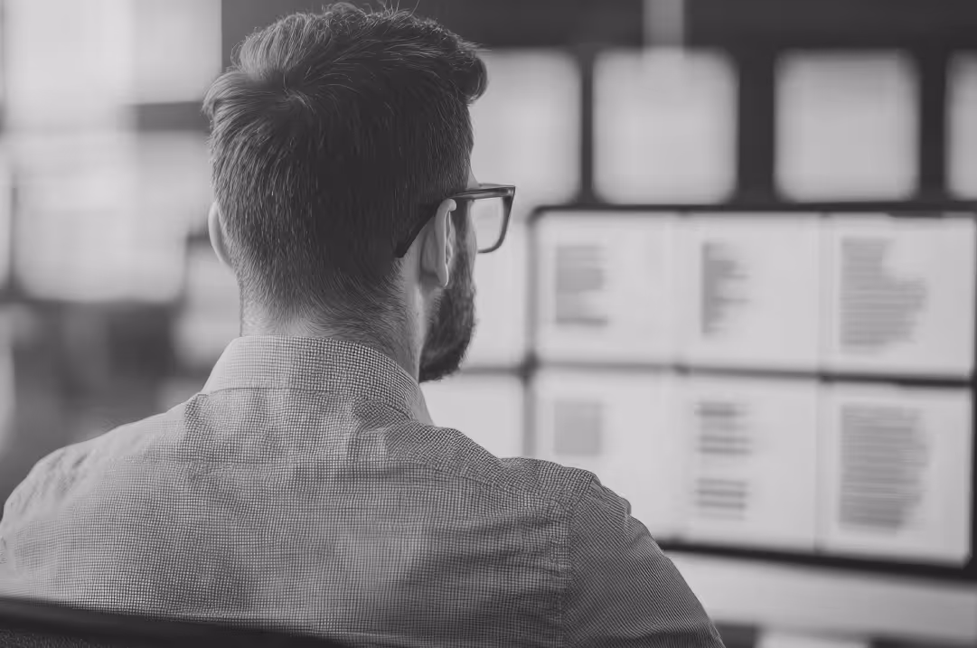 A person reviews documents on several monitors.