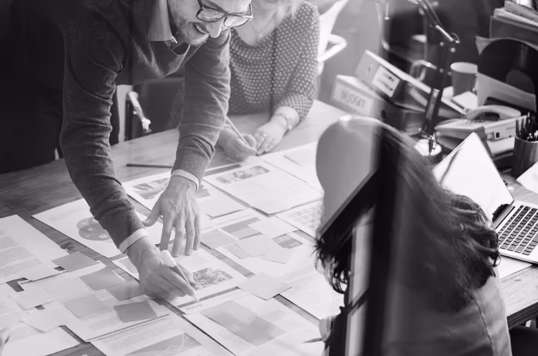 Team collaborating over documents and charts while planning modern B2B tech branding strategies.