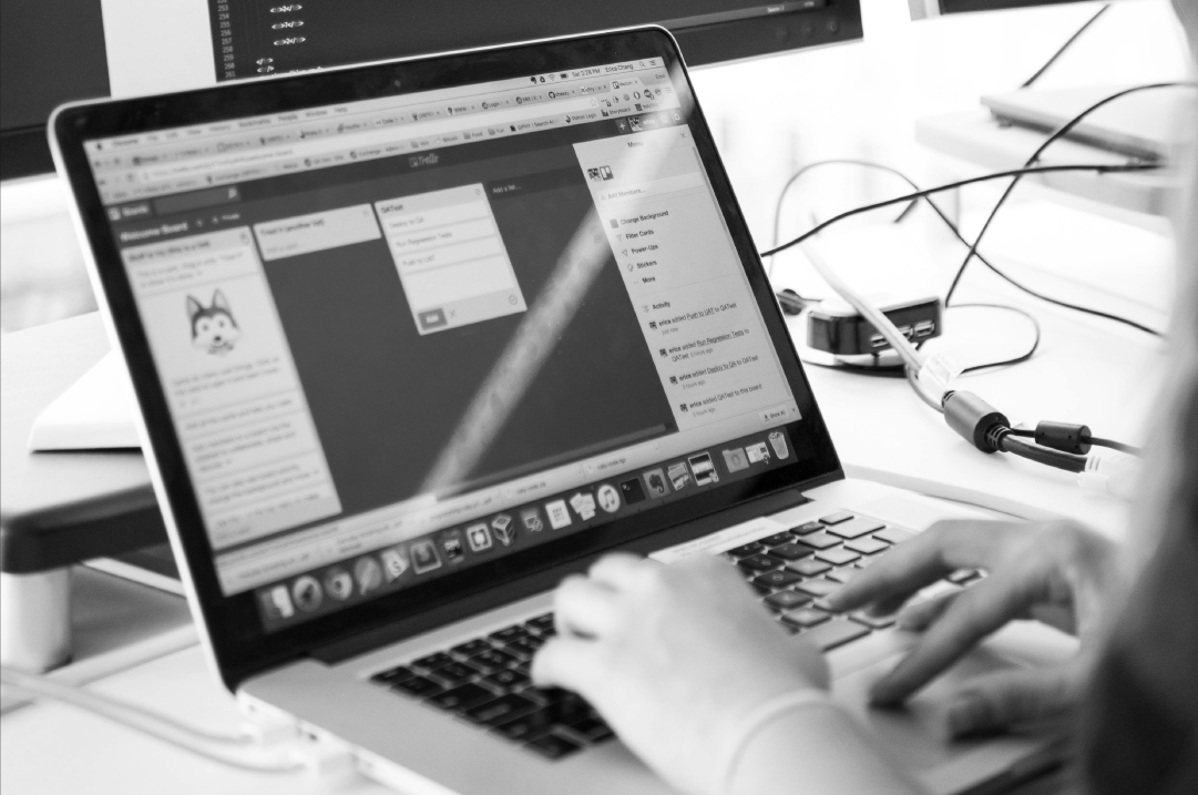 A pair of hands type on a laptop.