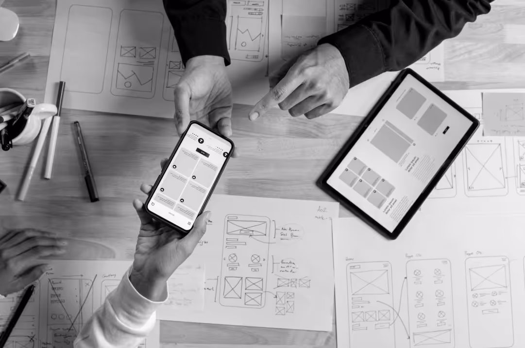 SaaS team reviewing mobile and tablet UI wireframes to improve user adoption.