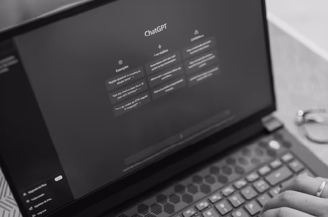 A laptop displays the ChatGPT interface.