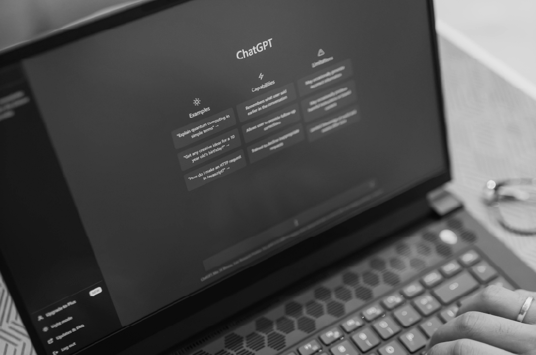 A laptop displays the ChatGPT interface.