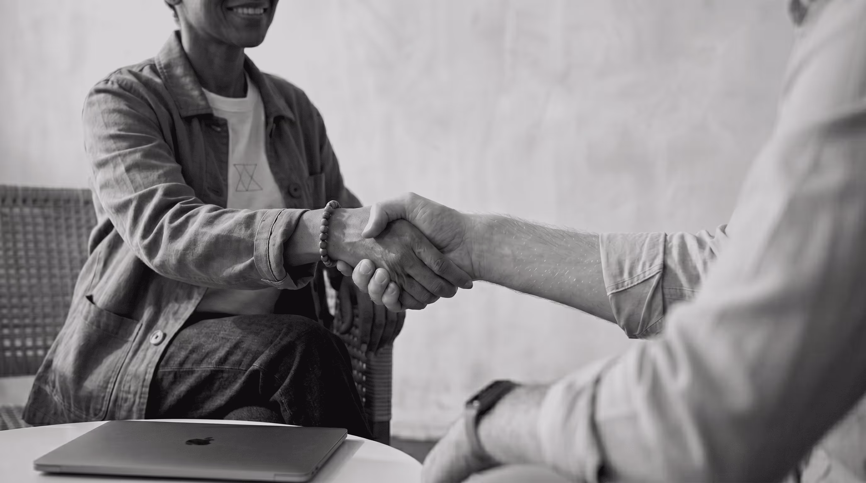 Two professionals closing a B2B agency partnership deal with a handshake
