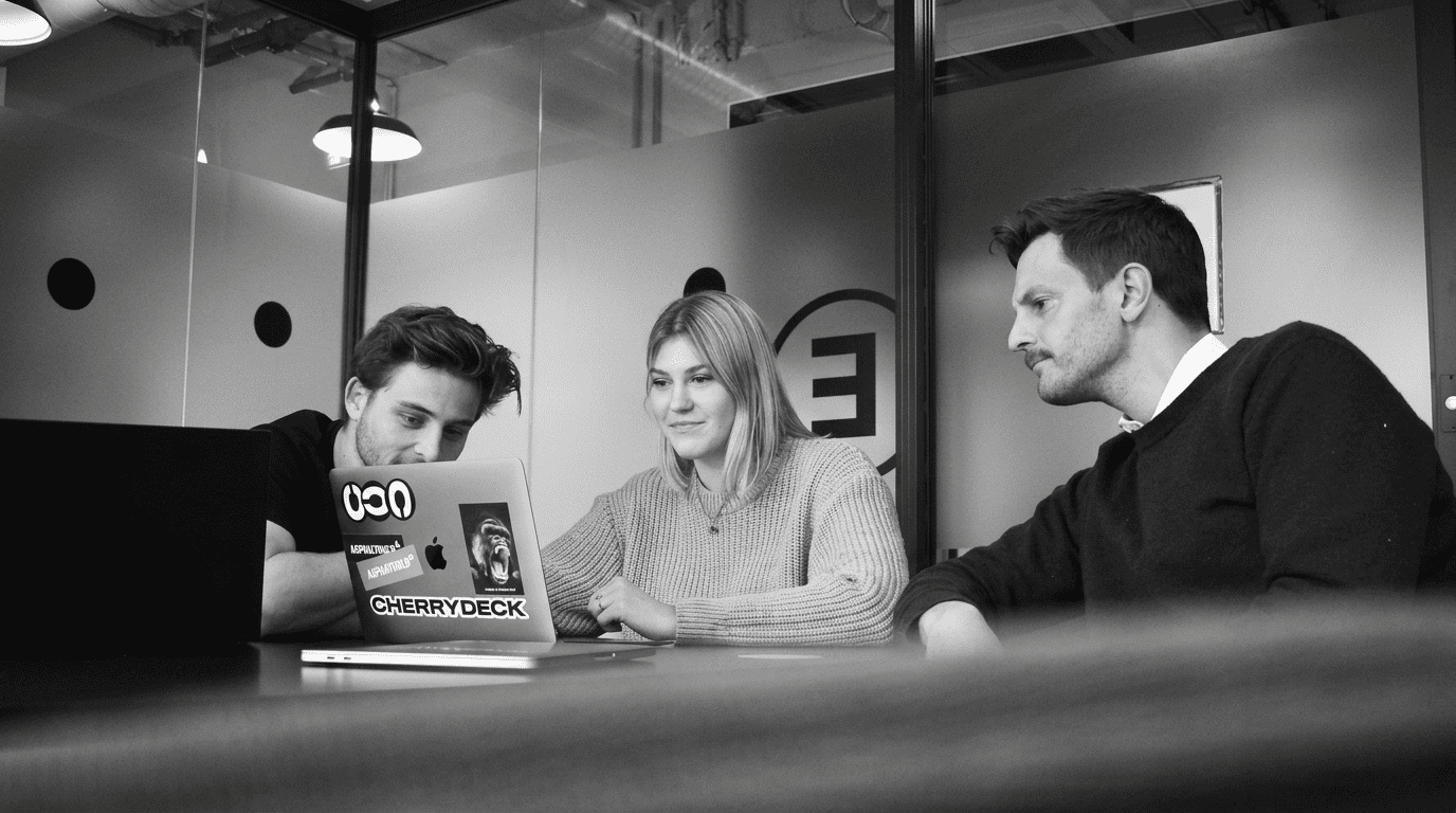 SaaS web design team reviewing agency vs in-house website strategy on a laptop.