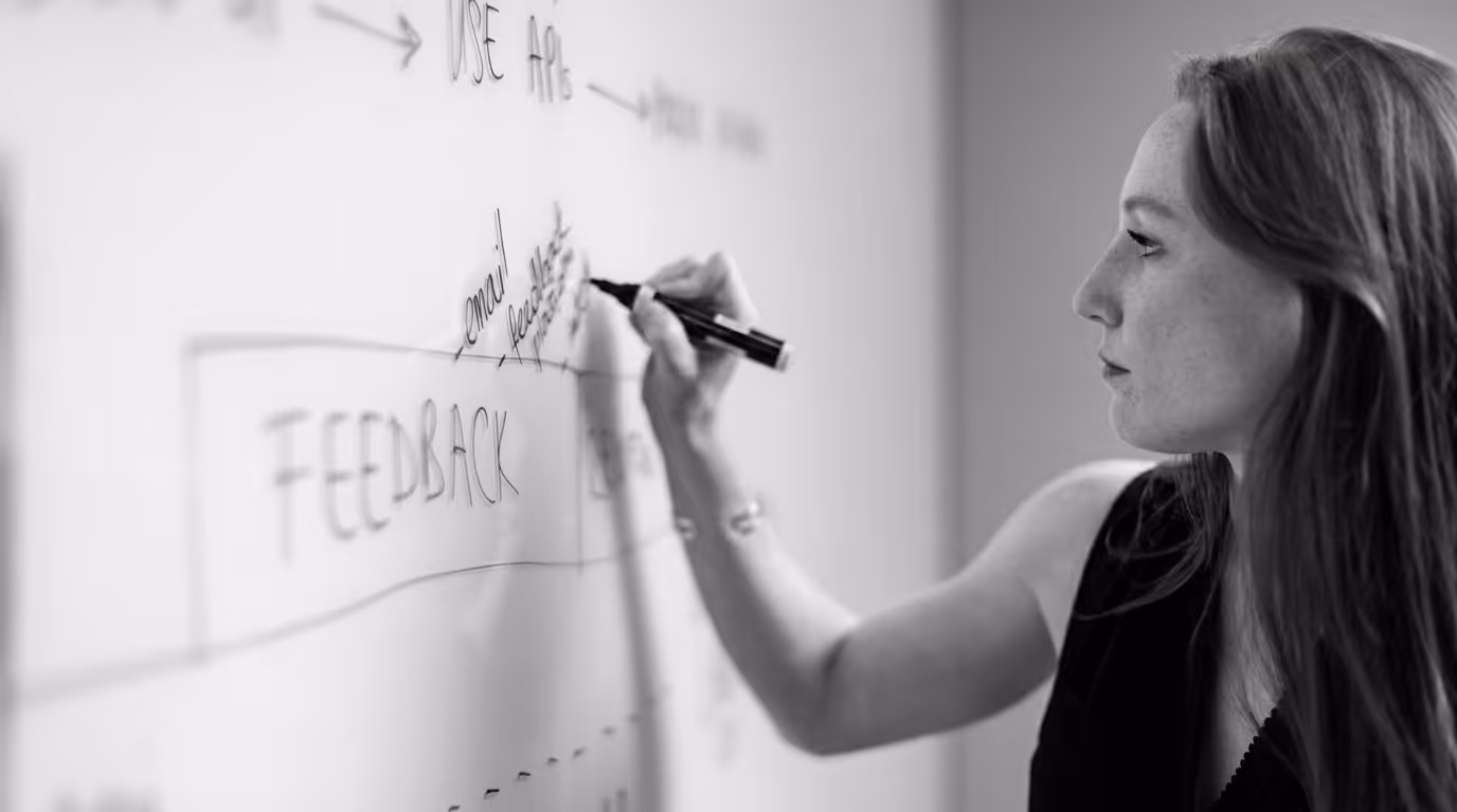 Product manager mapping SaaS architecture feedback on a whiteboard.