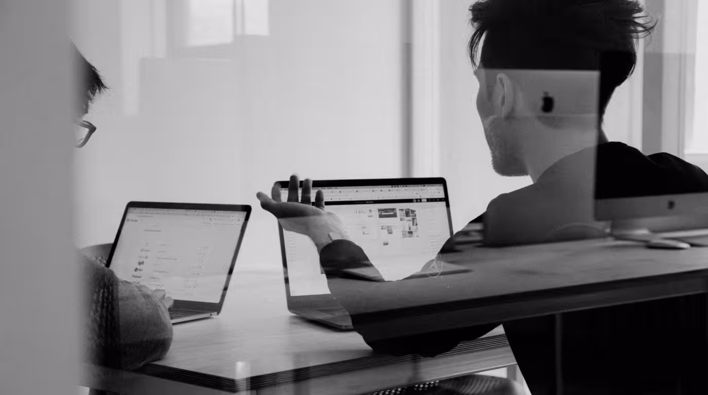 Double-exposure photo of two people working on laptops