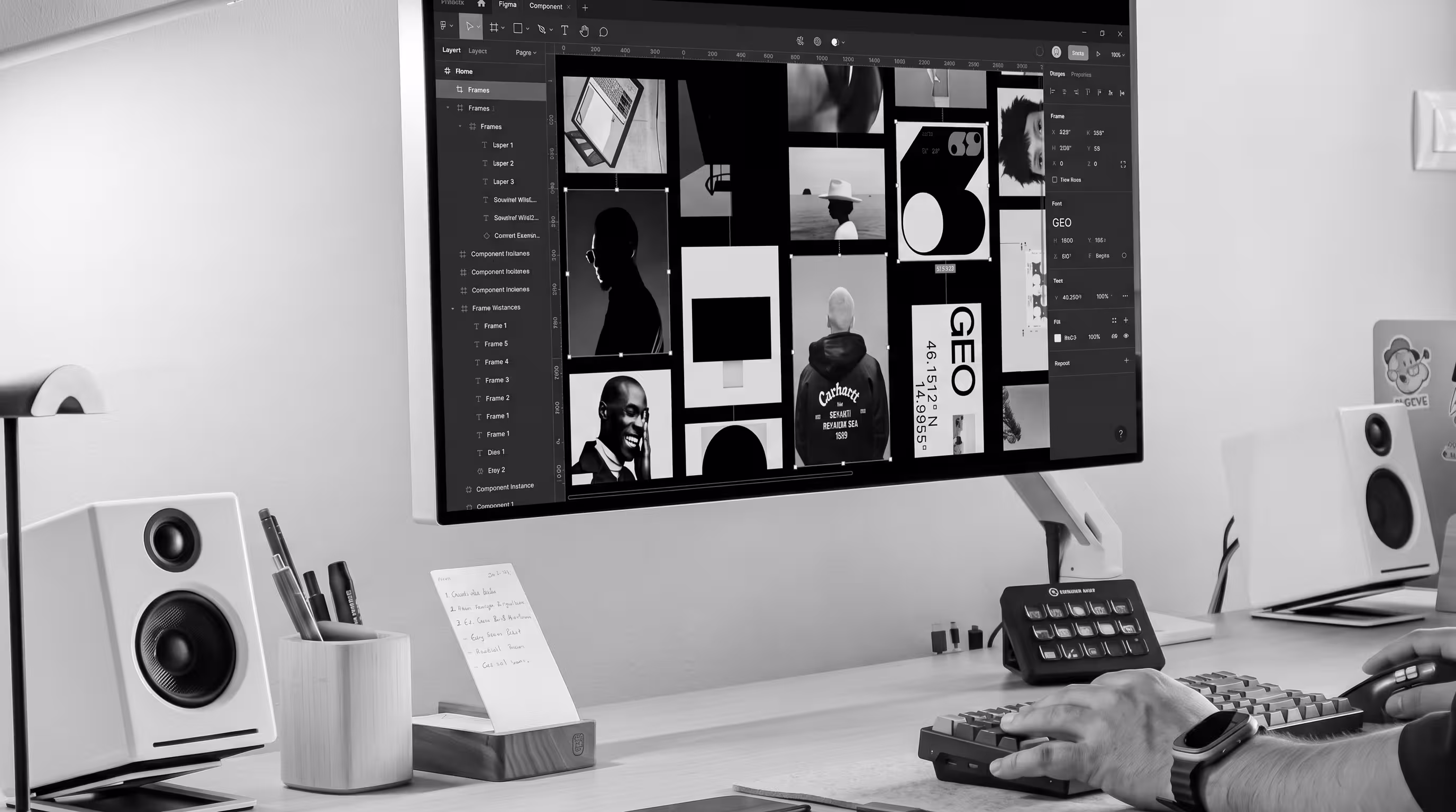 Black and white photo of a designer's desk with Figma open on a monitor