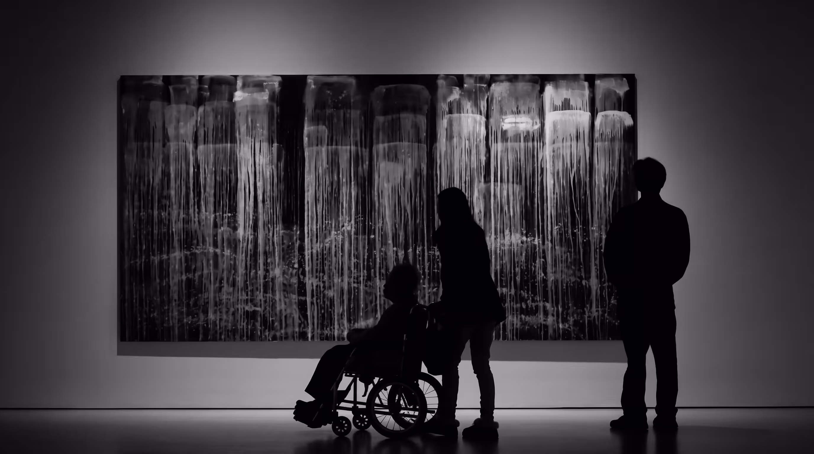 Black and white photo of museum visitors, including a person using a wheelchair