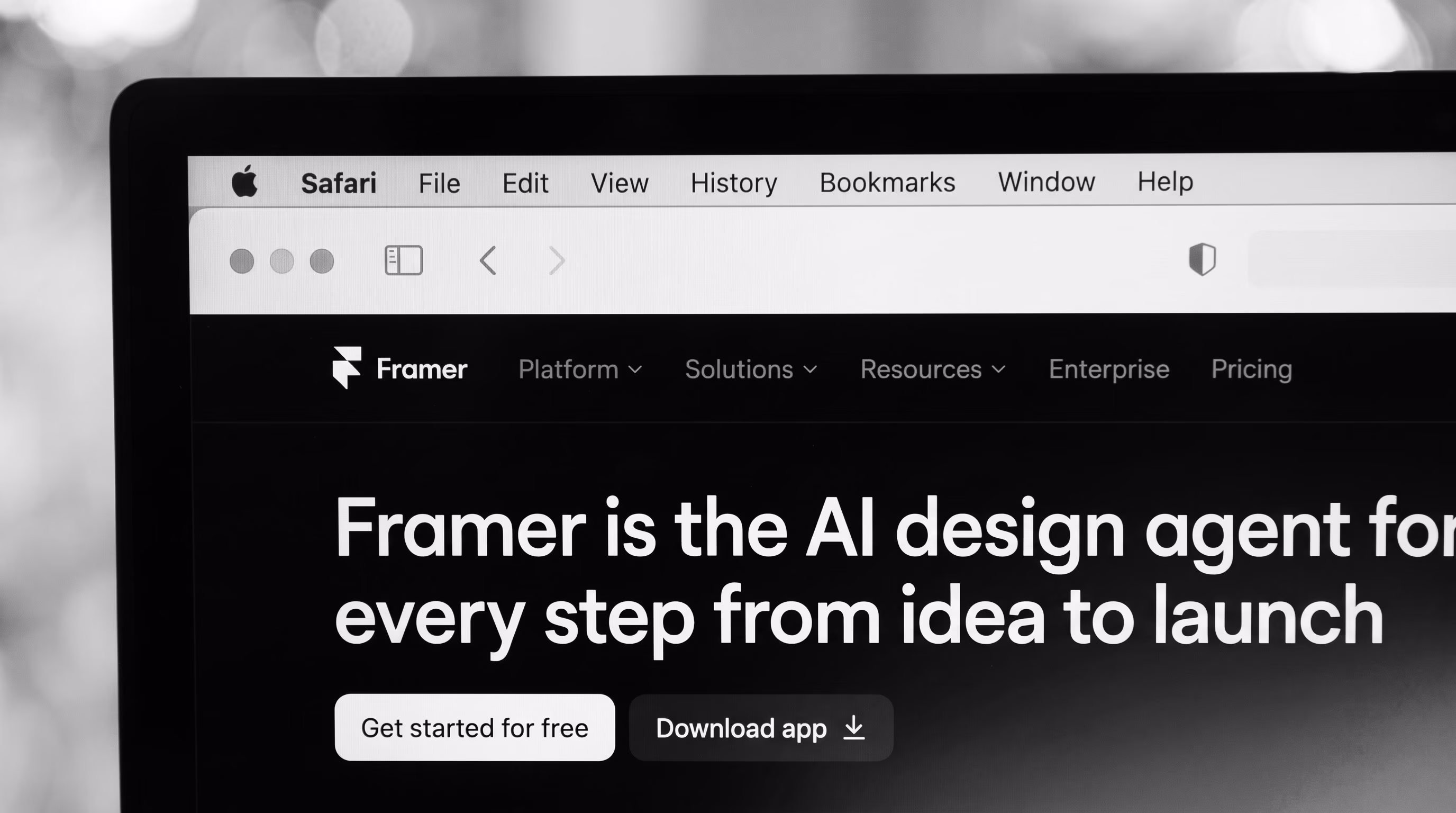 Screenshot of the Framer website in Safari with the headline 'Framer is the AI design agent for every step from idea to launch' and 'Get started for free' / 'Download app' buttons, black and white, inside a laptop mockup.