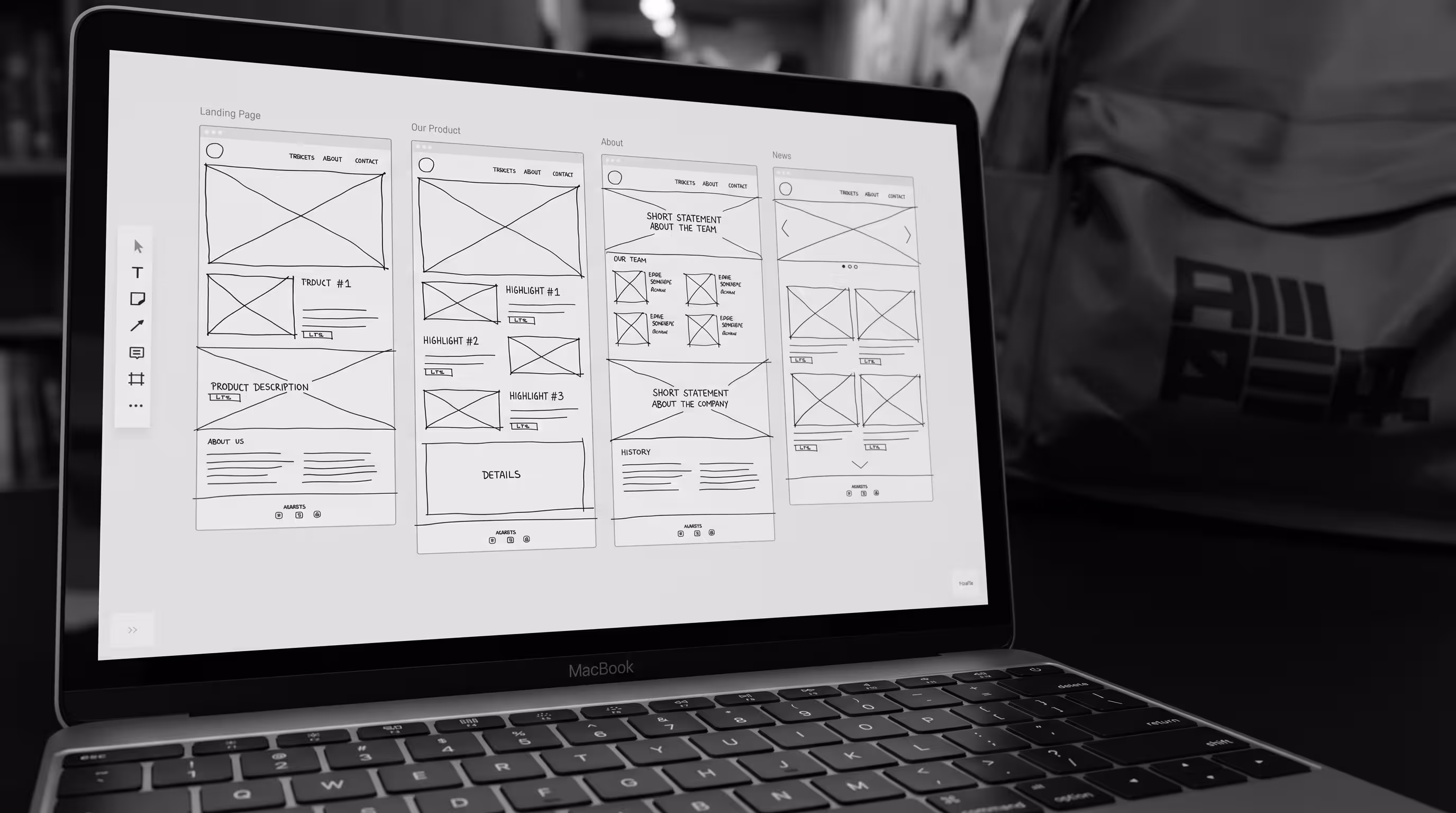 MacBook screen displaying sketched wireframes for a multi-page website layout