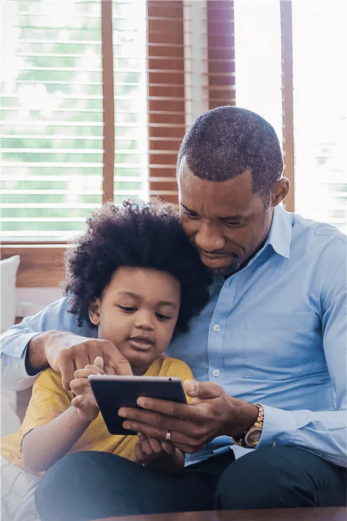 Child and adult looking at an ipad together