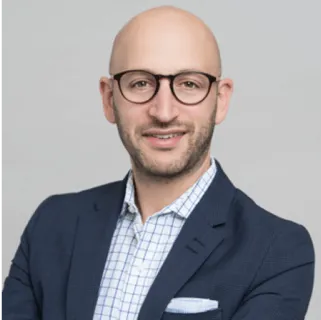 Headshot of Scott Daniels, General Manager, Leave Navigation at Wellthy, looking at the camera and smiling.