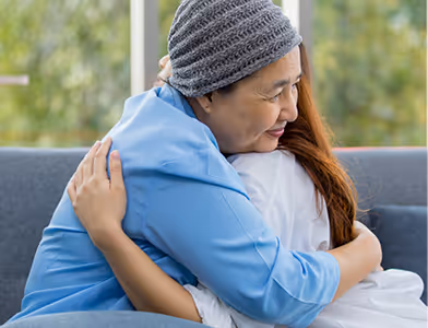 Woman in cancer treatment hugging her daughter