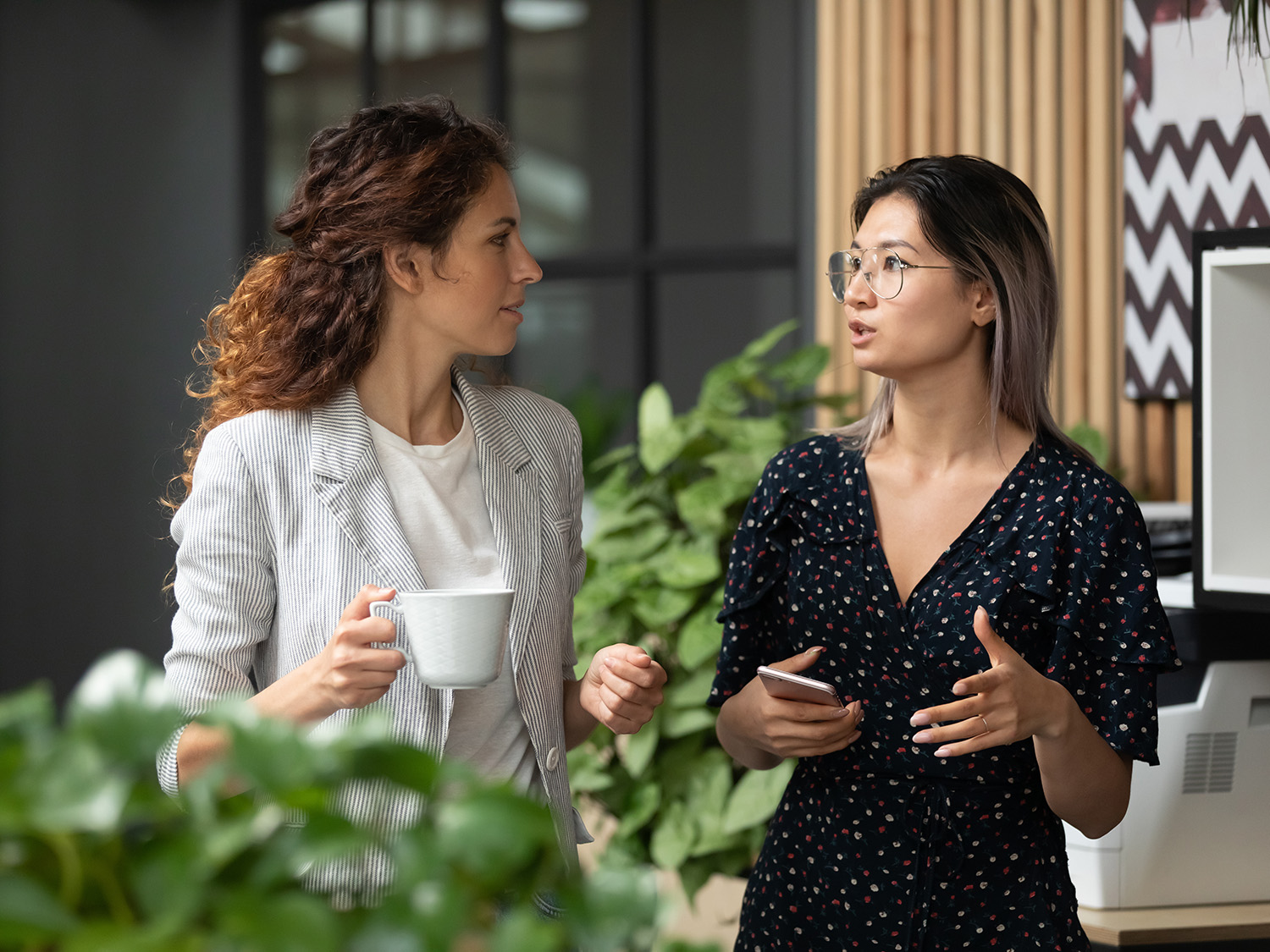 Two professionals chat over coffee