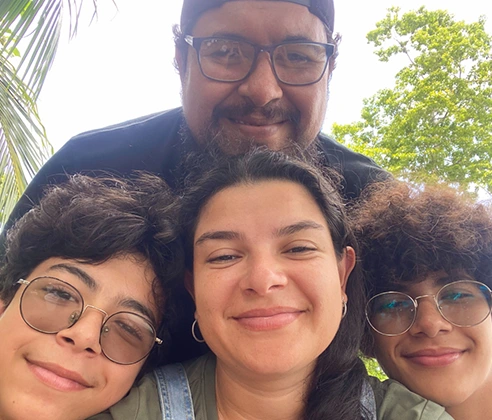 A selfie of a family - a father, mother, and their two teenage sons in their backyard