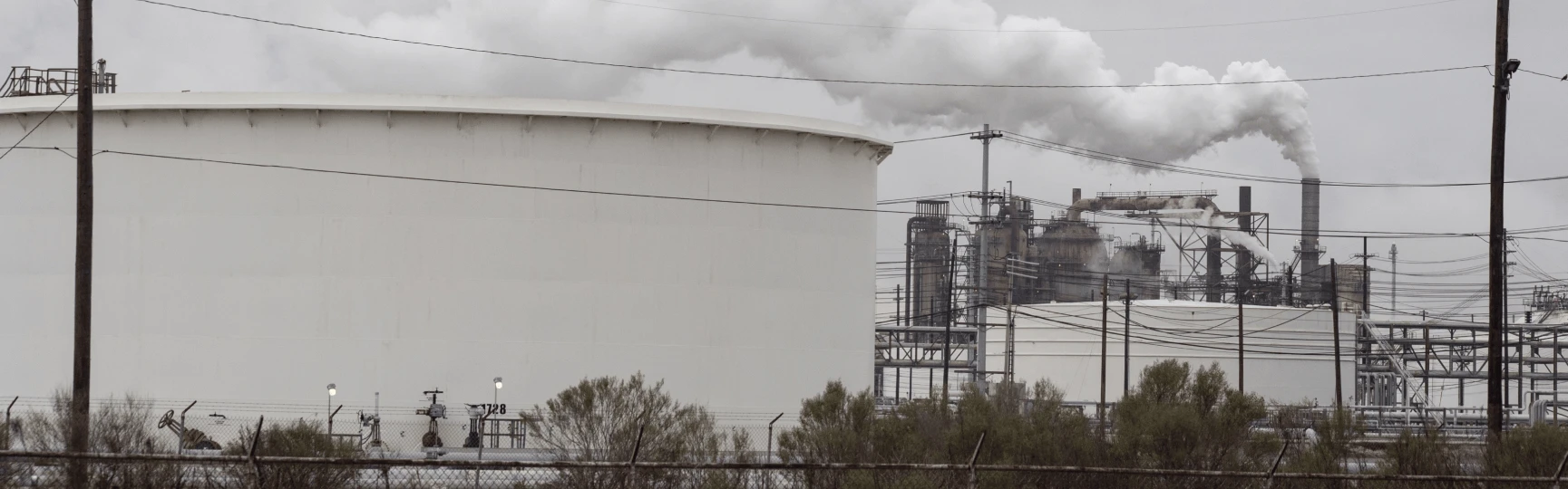 Petrochemical processing facilities with billowing smoke.