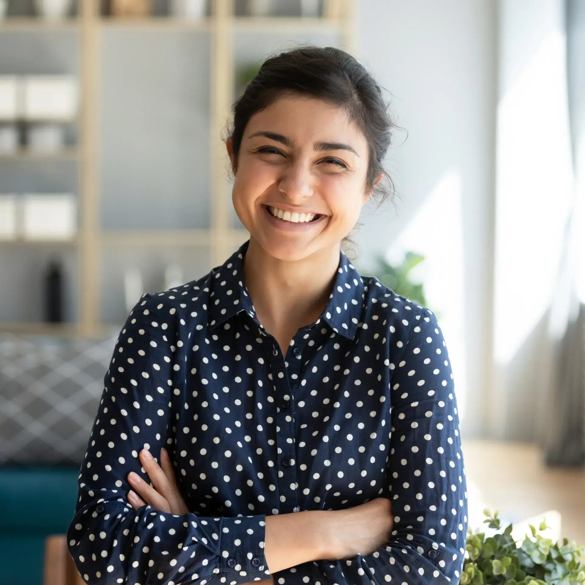 a woman standing with her arms crossed and smiling