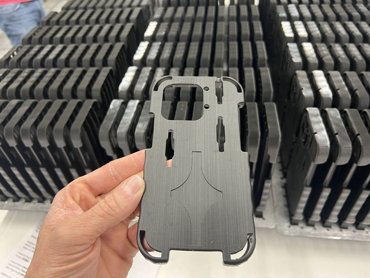 phone case 3d printed in foreground, background is a production run of cases
