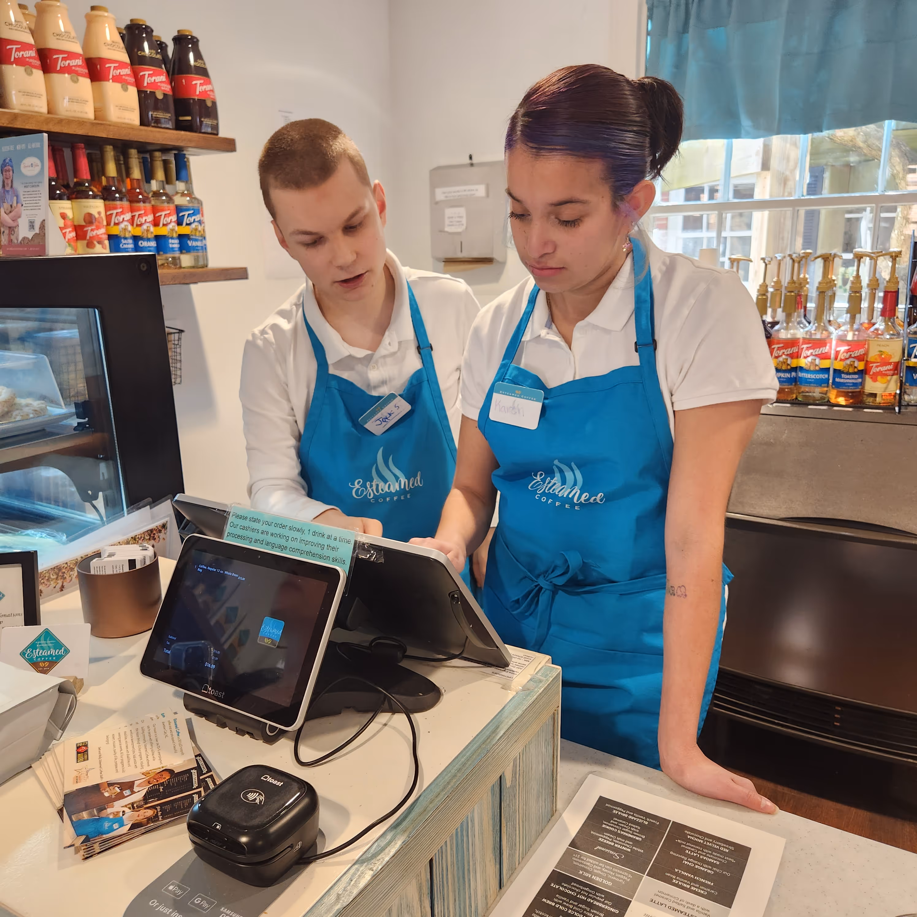 Cashier Jack training a new cashier, Karen