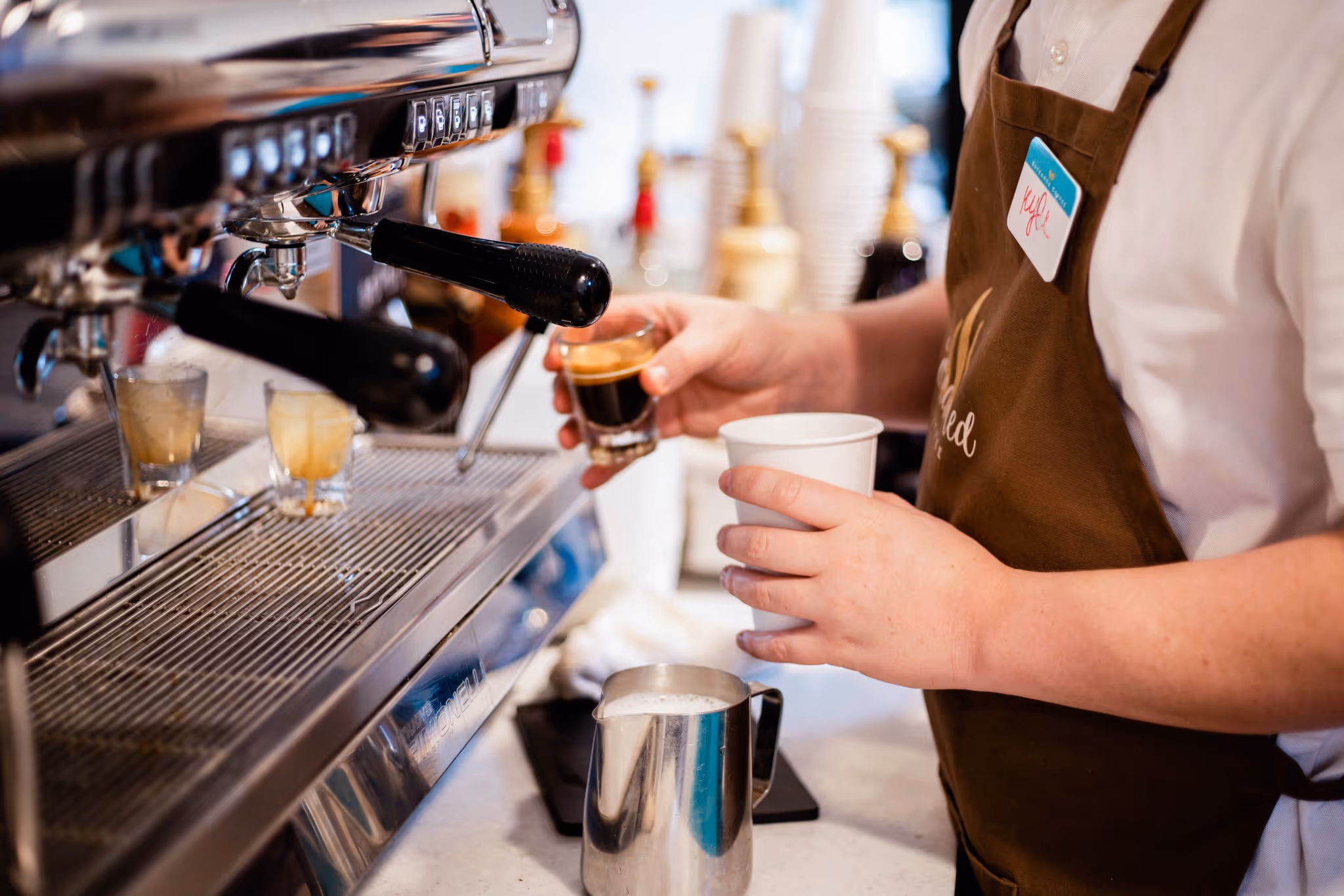 Barista pouring espresso into a cup