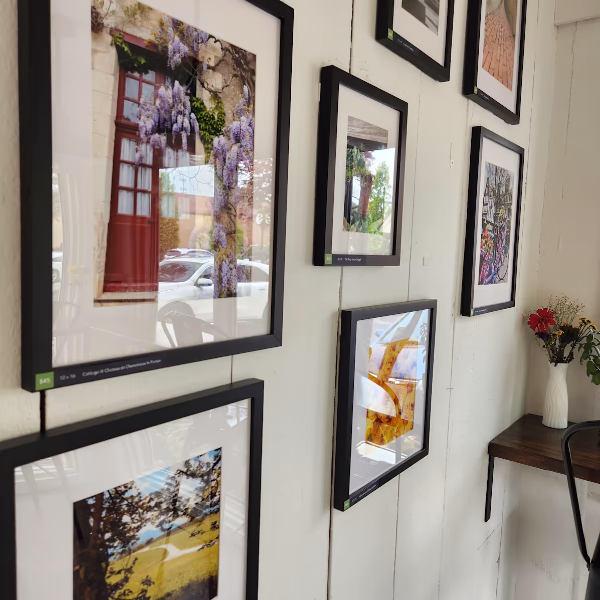 Framed photos on a wall by Austin Harrell