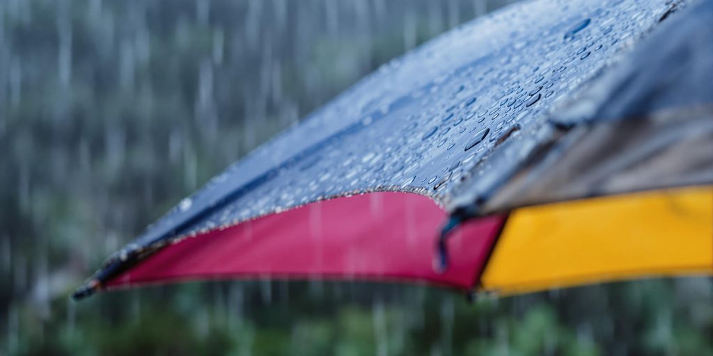 Colorful umbrella open in the rain with raindrops.