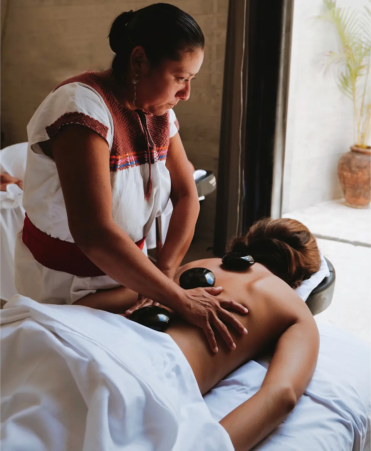 woman-performing-hot-stone-massage
