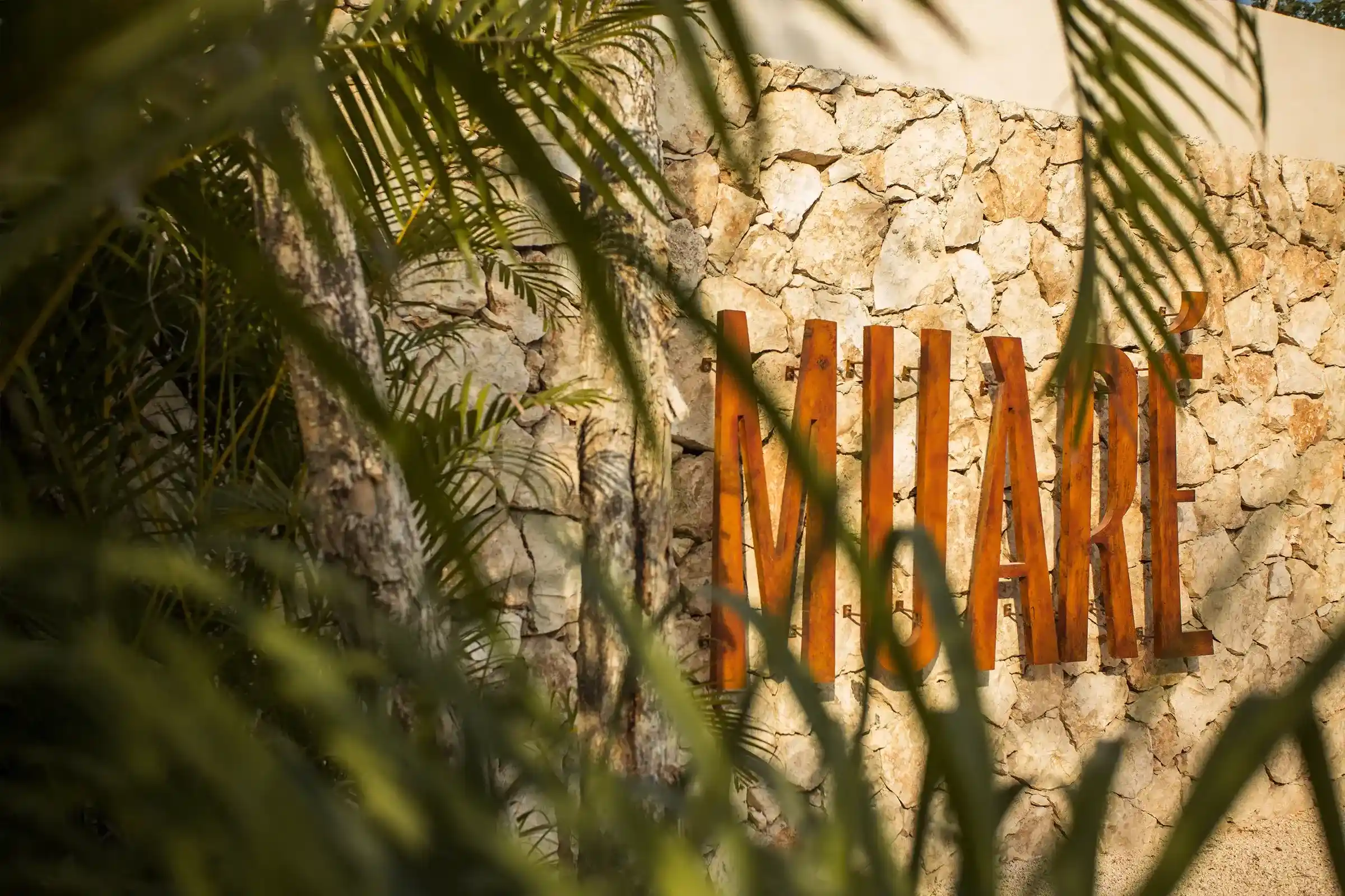 muro-piedra-letrero-madera-muare