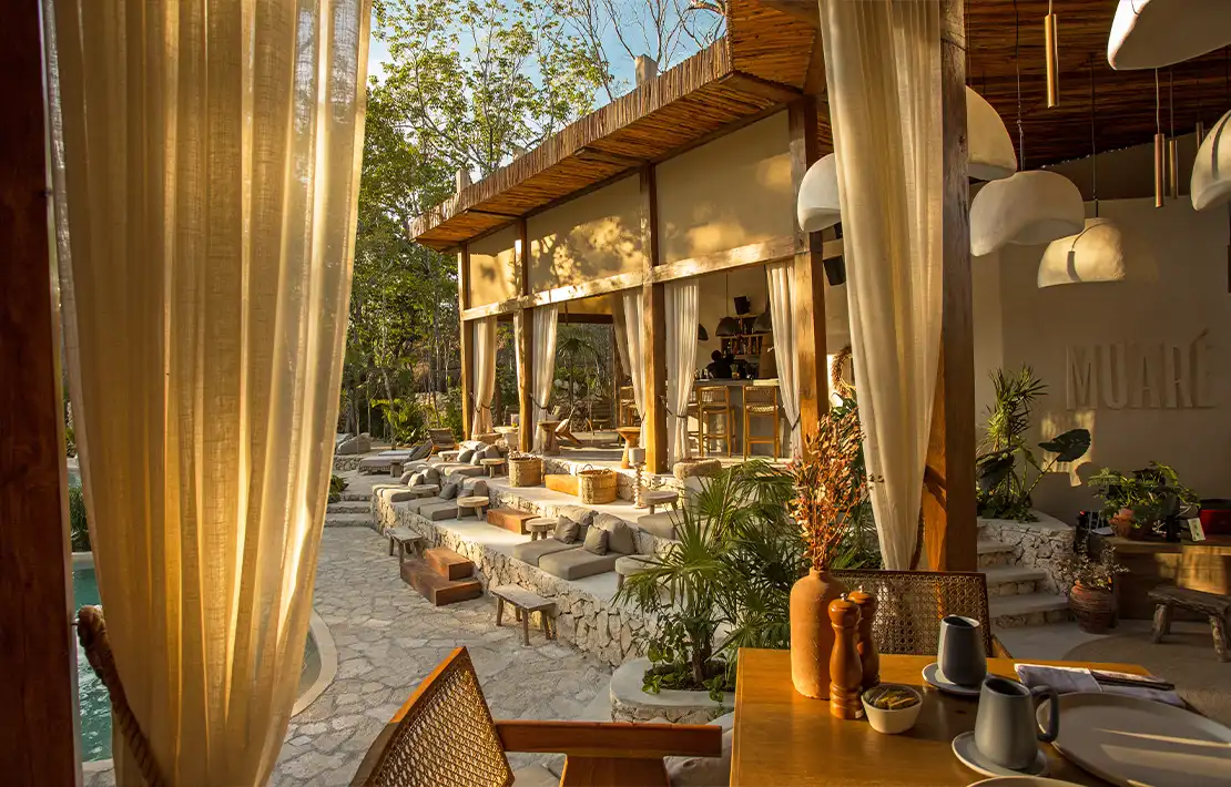 Mesa elegantemente decorada con velas, flores y copas de vino.