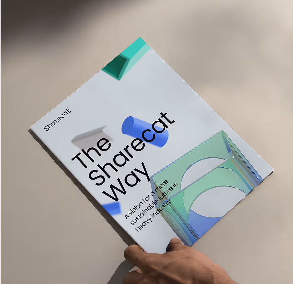 Photograph of a person's hand reaching to open Sharecat's strategy booklet, which is lying on a table.