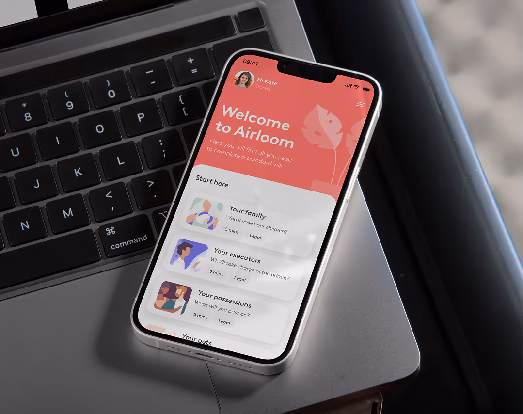 Photograph of a smartphone displaying the Airloom app welcome screen, resting on a laptop keyboard.